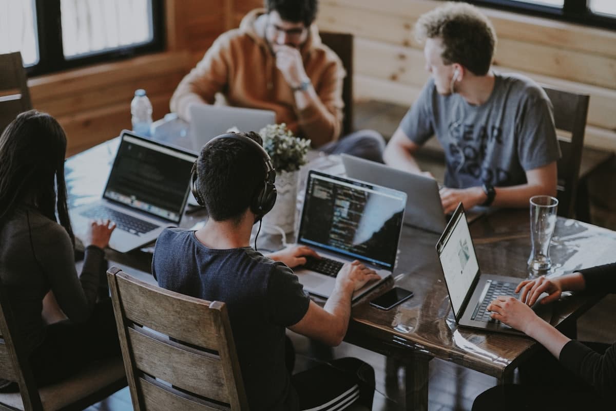 Une équipe au travail autour d'une table avec ses ordinateurs